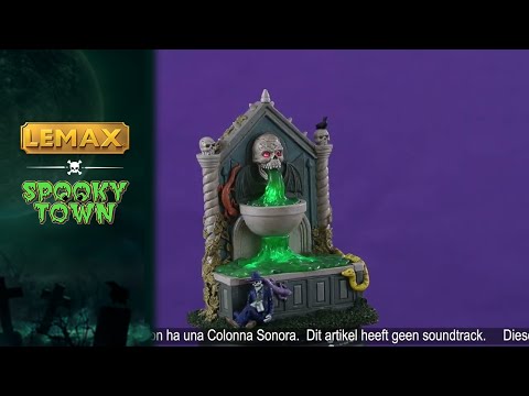 Resin village accent for a Lemax Spooky Town display. Designed to look like a well. The spout where the water is coming from is a skull with red eyes and bat wings. There are snakes and salamanders and a small skeleton man wearing a suit sitting at the bottom. The water is actually a bright green color.