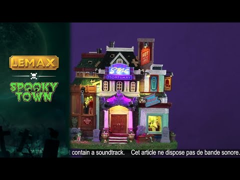 Resin lighted building for a Lemax display. Designed to look like a very colorful mortuary. There are tombstones in the front, and a zombie coming out of one of the graves. There are neon signs and inside the windows you can see zombie barbers.