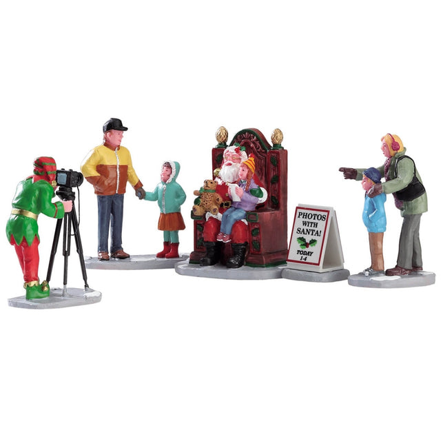 Polyresin figurines for a Lemax display. Designed to look like a bunch of people getting ready to take a picture with Santa. They're all wearing winter clothes. Santa is sitting on a throne and holding a teddy bear and a child. The photographer is dressed like an elf.