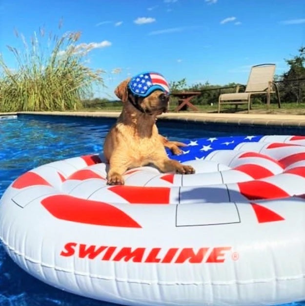 A pool float designed to look like a peace sign made out of the American flag.
