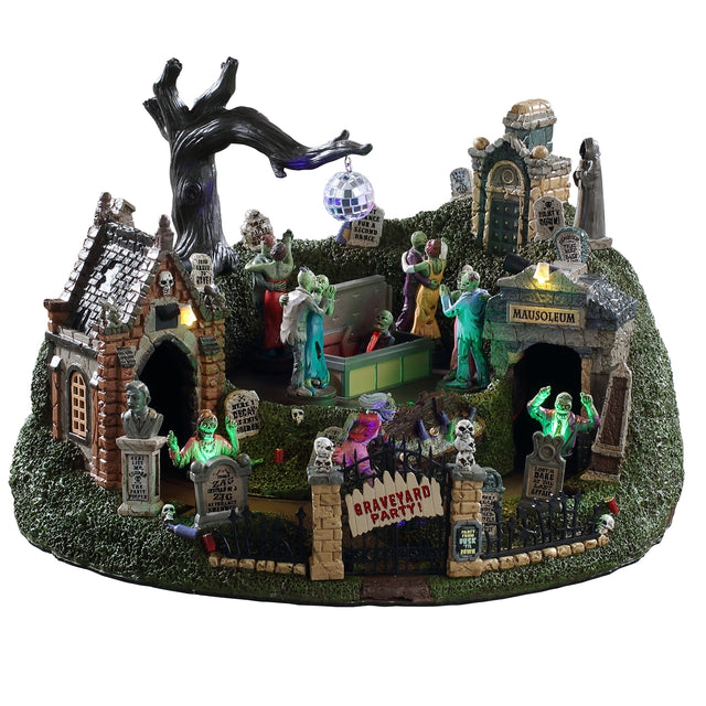 Animated polyresin village accent for a Lemax display. Designed to look like a graveyard with mausoleums and tombstones. There's a tree with a disco ball hanging off one of the branches and a bunch of monsters and skeletons dancing.