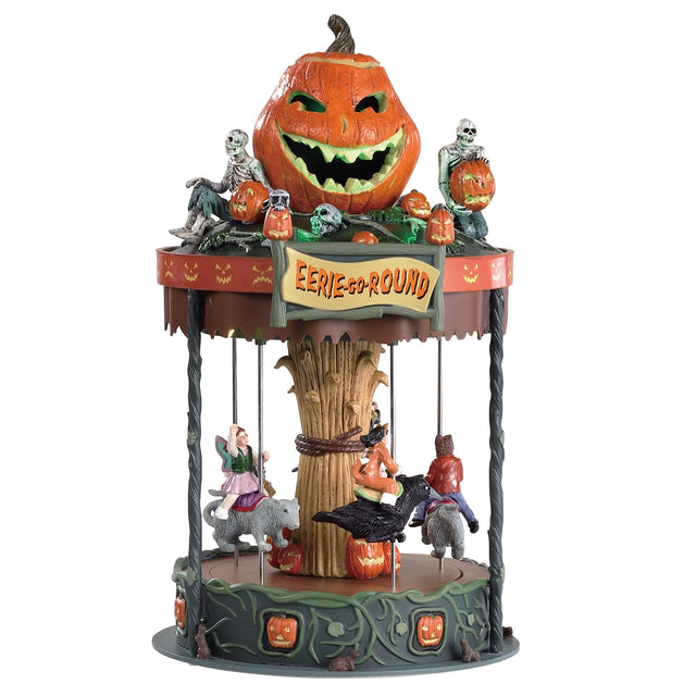 Polyresin village accent for a Spooky Town Lemax display. Designed to look like a merry-go-round that's pumpkin themed. There's a large jack-o-lantern and several smaller jack-o-lanterns and skeletons on the roof. There are kids riding the ride. Instead of horses, the children are riding on a rat, a crow and a broomstick.