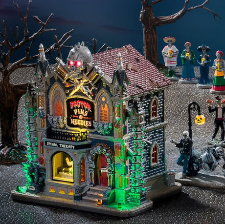 Porcelain lighted building for a Lemax display. Designed to look like a Victorian-era building with a skull statue on the roof and columns made out of spines. Inside the window you can see the doctor examining a monster.