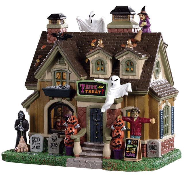 Porcelain house for a Lemax display. Designed to look like a house that's been decorated for Halloween. There are ghosts, witches, carved pumpkins and tombstones.