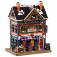 Porcelain lighted building for a Lemax display. Designed to look like a large dog supply store decorated for Halloween. There are ghosts on the roof, pumpkin lights hanging from the roof and a sign with pumpkins that reads "HOWL-O-WEEN SUPER SALE." There are dogs playing in front of the store. There's a sign on the sidewalk that reads "TODAY! SPOOKY PHOTO SHOOT!"