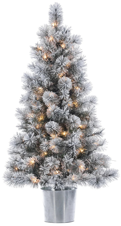 White potted artificial tree pre-lit with warm white lights. It's in a silver base.