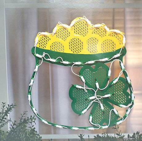 Lighted St. Patrick's Day decoration shaped like a green pot with gold coming out of it. There's also a shamrock on the pot.