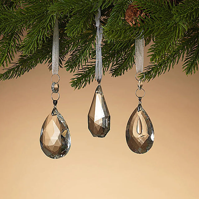 Gem shaped ornament hanging from a sheer ribbon.