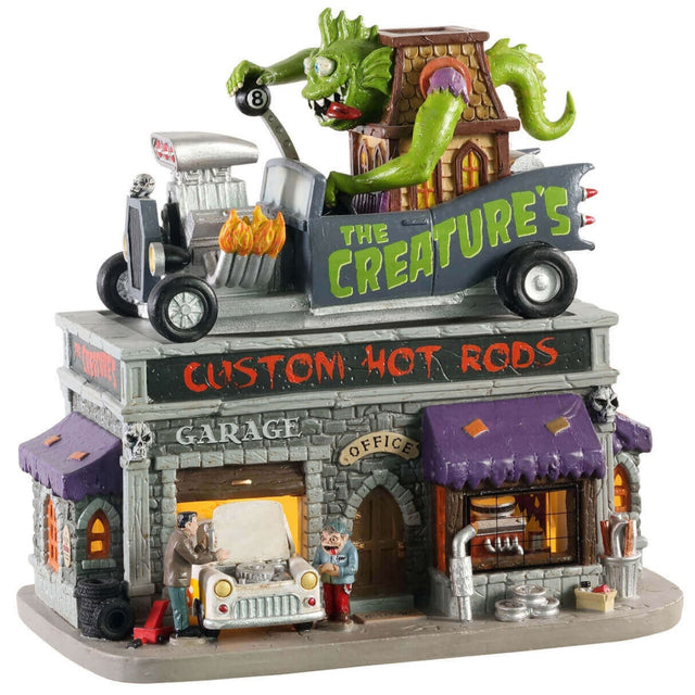 Polyresin and porcelain building for a Lemax Spooky Town display. Designed to look like a mechanic who does custom paint jobs for cars. There's a large green monster on the top, driving a giant car shaped like a house. The sign on the sign of the building reads "THE CREATURE'S."