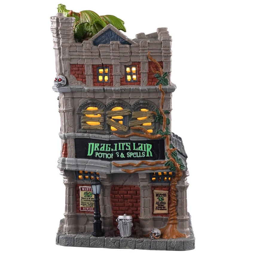 Porcelain lighted building for a Lemax display. Designed to look like a tall, old department store. The signs read "DRAGON'S LAIR POTIONS & SPELLS." There's a green monster on the roof. There are lampposts and a jack-o-lantern accent outside.