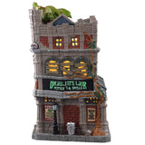 Porcelain lighted building for a Lemax display. Designed to look like a tall, old department store. The signs read "DRAGON'S LAIR POTIONS & SPELLS." There's a green monster on the roof. There are lampposts and a jack-o-lantern accent outside.