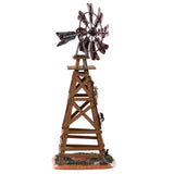 Polyresin table accent for a Lemax display. Designed to look like a wooden windmill with metal blades. There are two signs on it that read "DANGER!" and "BEWARE OF FALLING BLADES!" The danger sign has a small owl sitting on it. The beware sign has a big, black spider on it. There's a little bit of grass and dirt on the ground underneath it. There's a small rat standing at the bottom.