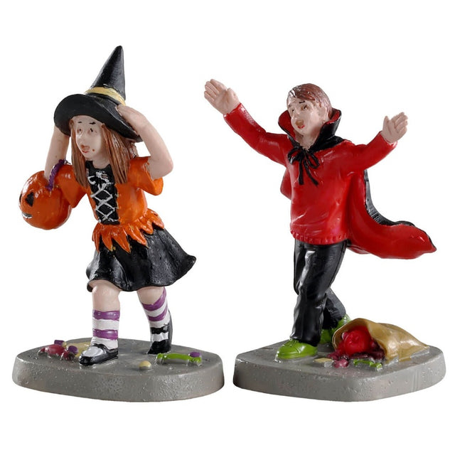 Polyresin figurines for a Lemax display. Designed to look like two kids wearing costumes. The boy is dressed as a vampire and dropped his bag of candy. He's scaring the girl who is dressed as a witch and holding a pumpkin container for her candy.