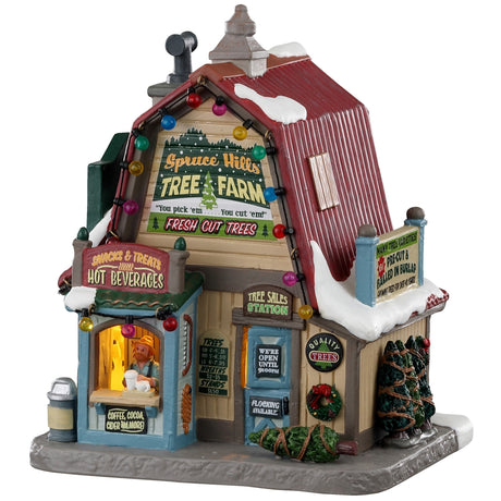 Porcelain lighted building for a Lemax Village tabletop display. It reads "Spruce Hills Tree Farm. Fresh cut trees." It's covered in snow and has multi-colored lights on it. There are a few wrapped up trees on the side and a person at the front booth serving beverages.