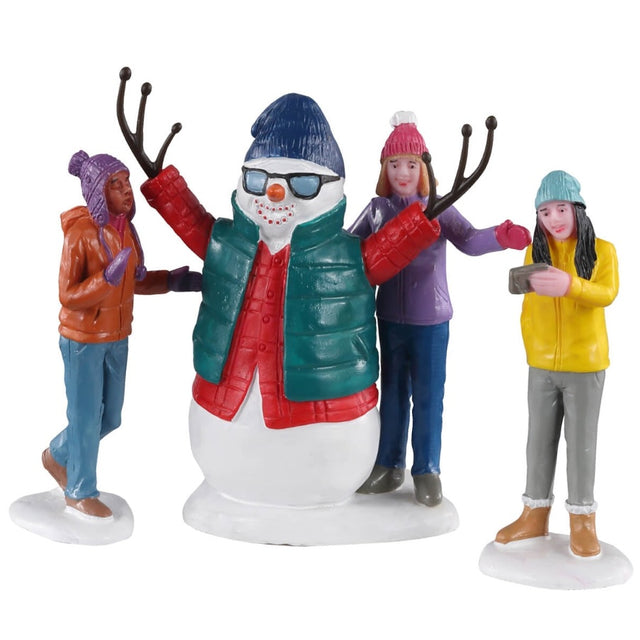Polyresin figurines for a Lemax Village tabletop display. Designed to look like a trio of friends putting clothing on a snowman