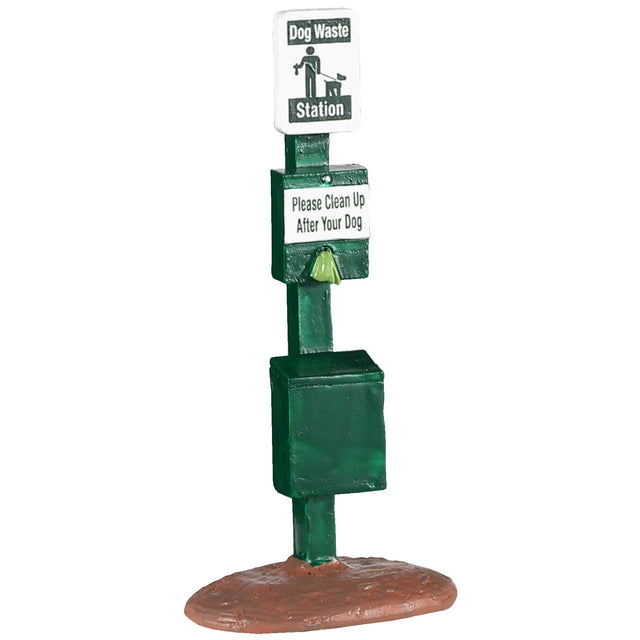 Polyresin figurine for a Lemax Village tabletop display. Designed to look like a green dog waste station that reads "Please clean up after your dog"