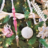Glitter ornaments shaped like round pine cones. One is silver with gold tips and the other is gold with silver tips.