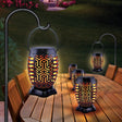 This is a lifestyle image showing two lanterns hanging and three lanterns in the center of a table.
