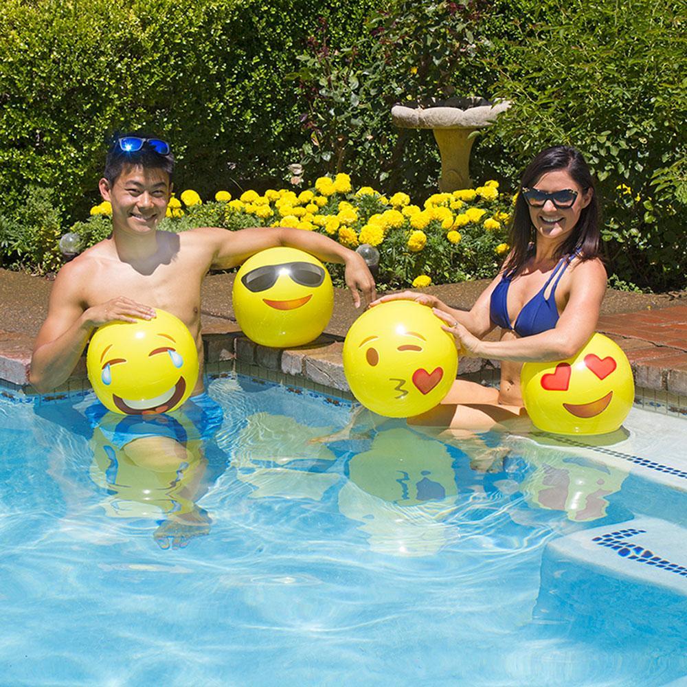 Yellow beach balls designed to look like different emojis.