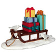 Polyresin figurine for a Lemax display. Designed to look like a brown sled with four multi-colored, wrapped gifts on it. There are two white birds.