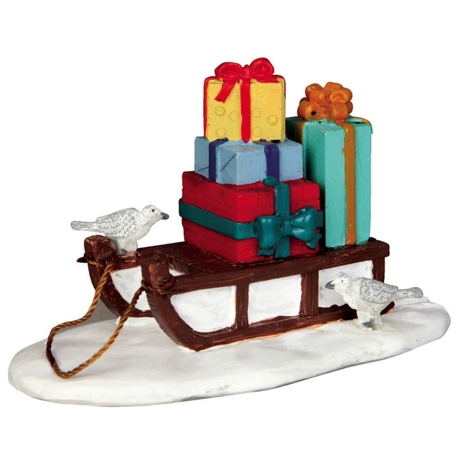 Polyresin figurine for a Lemax display. Designed to look like a brown sled with four multi-colored, wrapped gifts on it. There are two white birds.