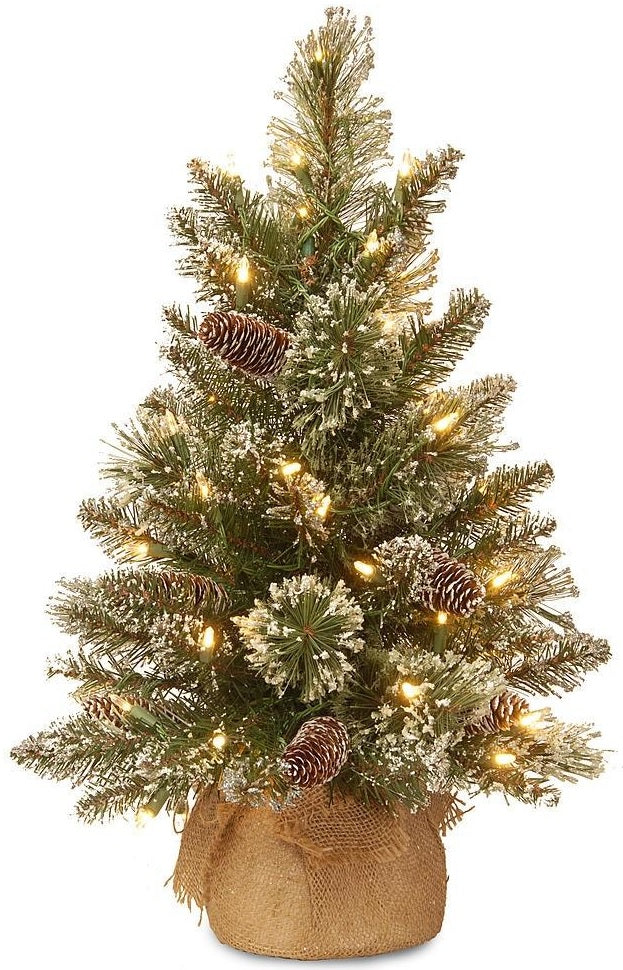 A small tabletop tree in a burlap base. The branches are covered in white glitter. There are warm white lights and pine cone accents.
