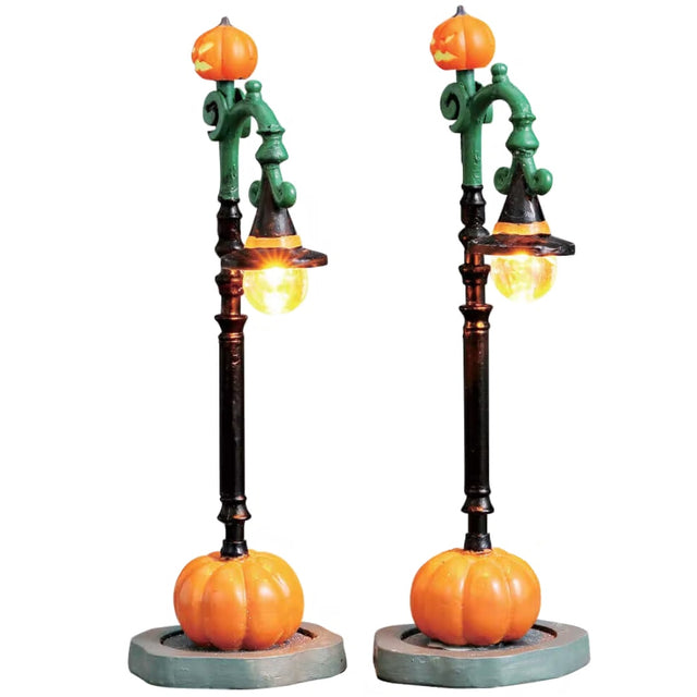 Polyresin figures for a Lemax display. Designed to look like two lampposts decorated for Halloween. There are jack-o-lanterns on top and the lights are shaped like witch hats. The bases have a pumpkin.