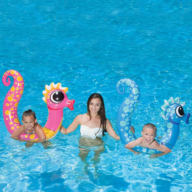 Pool inflatables shaped like seahorses. One is pink and one is blue.