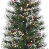 2 potted artificial trees. The tree tips are white to look like snow. The lights are warm white and there are red berry accents.