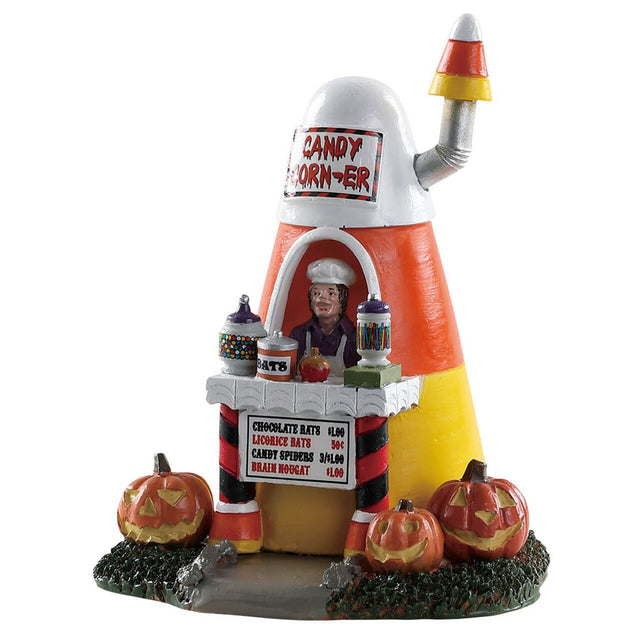 Polyresin figure for a Lemax display. Designed to look like a food booth shaped like a piece of candy corn. The menu features chocolate bats, licorice bats, candy spiders and brain nougat. There are carved pumpkins on the ground.