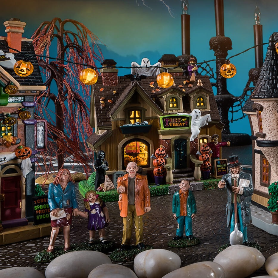Porcelain house for a Lemax display. Designed to look like a house that's been decorated for Halloween. There are ghosts, witches, carved pumpkins and tombstones.