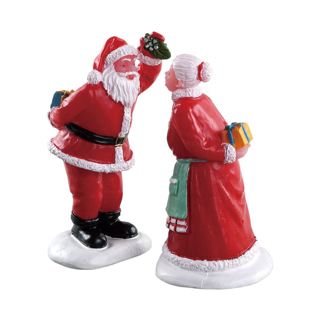 Village figurines for a Lemax display. Designed to look like Santa Claus holding mistletoe, about to kiss Mrs. Claus. They're both holding gifts behind their backs.