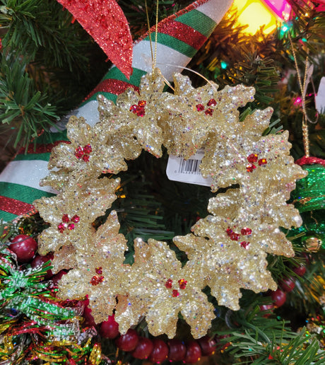 Gold glitter ornament shaped like a wreath with red berry accents.