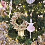 Gold glitter ornament shaped like a wreath with red berry accents.