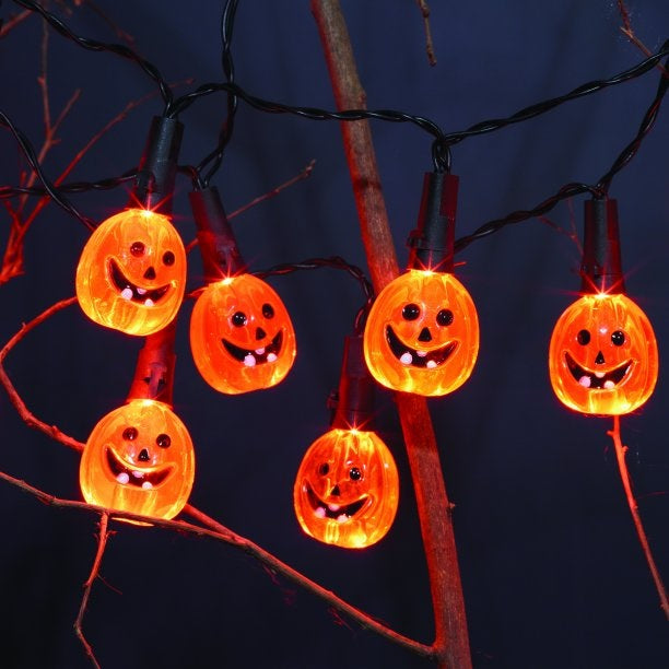 LED lights shaped like smiling jack-o-lanterns on a black wire.