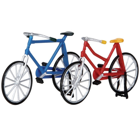 Plastic bikes for a Lemax Village display. One bike is blue with a black bike seat. The other bike is red with a yellow seat.