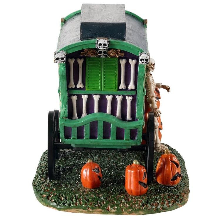 Polyresin village accent for a Lemax display. Designed to look like a green, purple and red cart that reads "PUMPKIN FESTIVAL." There are jack-o-lanterns on the ground and a skeleton standing next to the cart.