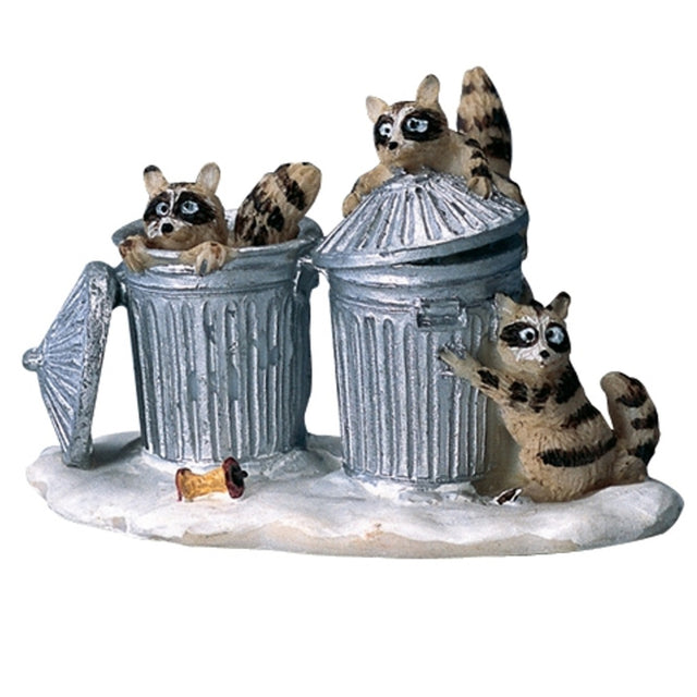 Polyresin figurine for a Lemax display. Designed to look like three raccoons digging through two shiny, silver garbage cans. There's a half eaten apple core on the ground. The ground appears to be covered in snow.