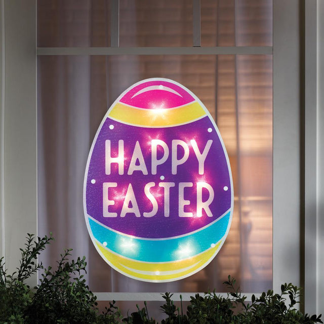 A window silhouette shaped like an egg that reads "HAPPY EASTER." The colors are pink, yellow, purple and light blue. The sign lights up.