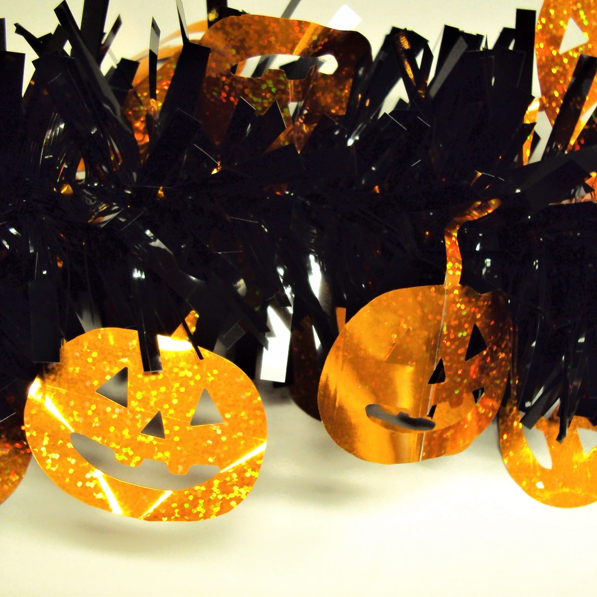 Black tinsel garland with holographic, orange pumpkins.