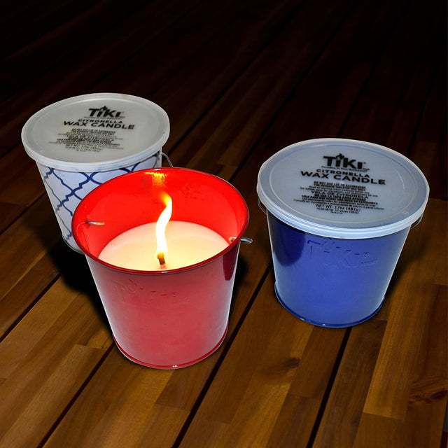 This picture shows the different color options for these TIKI candles. One candle is in a white and blue tin bucket. One candle is in a shiny, red tin bucket. The other candle is in a shiny, blue tin bucket.