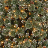 Artificial tree pre-lit with dual lights. Lights change from warm white to multi-colored. Branches are covered in white glitter.
