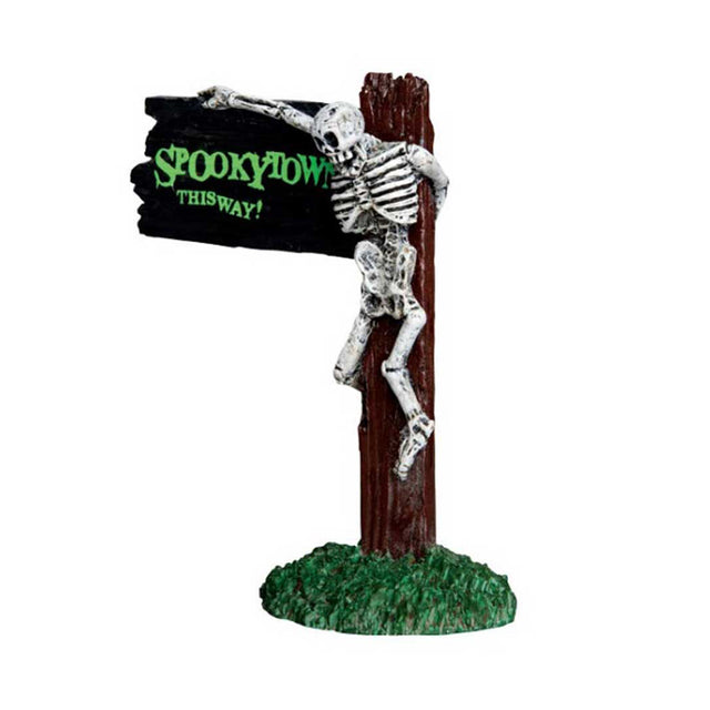 Polyresin figurine for a Lemax display. Designed to look like a sign that reads "SPOOKY TOWN THIS WAY!" There's a skeleton hanging from the sign.
