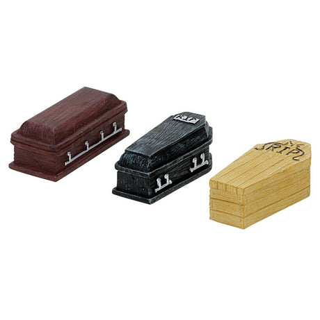 Polyresin village accents for a Lemax display. Designed to look like three coffins. One is brown, one is black and reads RIP and another is made out of a yellow-ish tan wood and reads RIP.