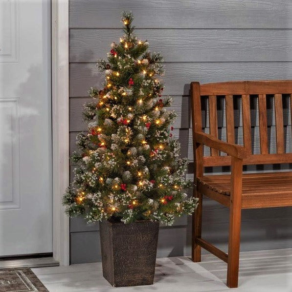 Potted artificial tree. The tree tips are white to look like snow. The lights are warm white and there are red berry accents.