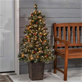 Potted artificial tree. The tree tips are white to look like snow. The lights are warm white and there are red berry accents.
