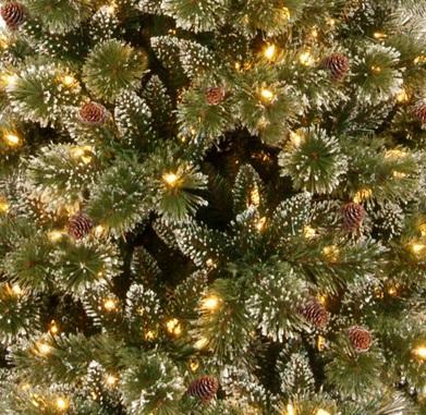 Pre-lit artificial tree with clear lights and pine cones.