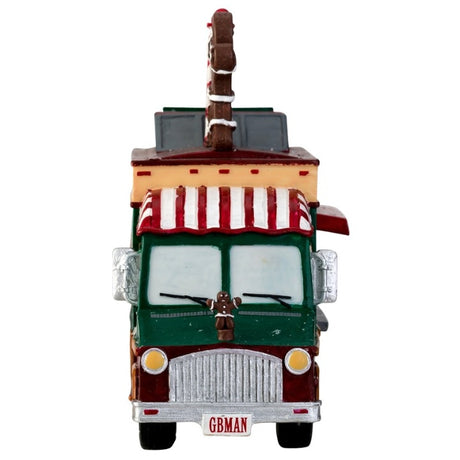 Village accent for a Lemax display. Designed to look like a food vendor truck that serves cupcakes, hot cider and gingerbread. There's a dog waiting patiently for a free sample.