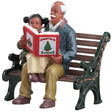 Village accent for a Lemax display. Designed to look like a Grandpa reading Christmas stories to a young girl who is sitting on his lap. They're both sitting on a wooden bench.