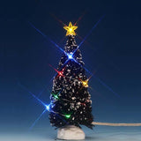 Lemax village accessory designed to look like a snow-covered tree that has multi-colored lights on it and a yellow star on top.